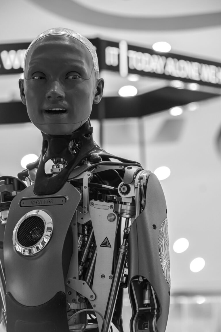 Close-up of a futuristic humanoid robot head in black and white.