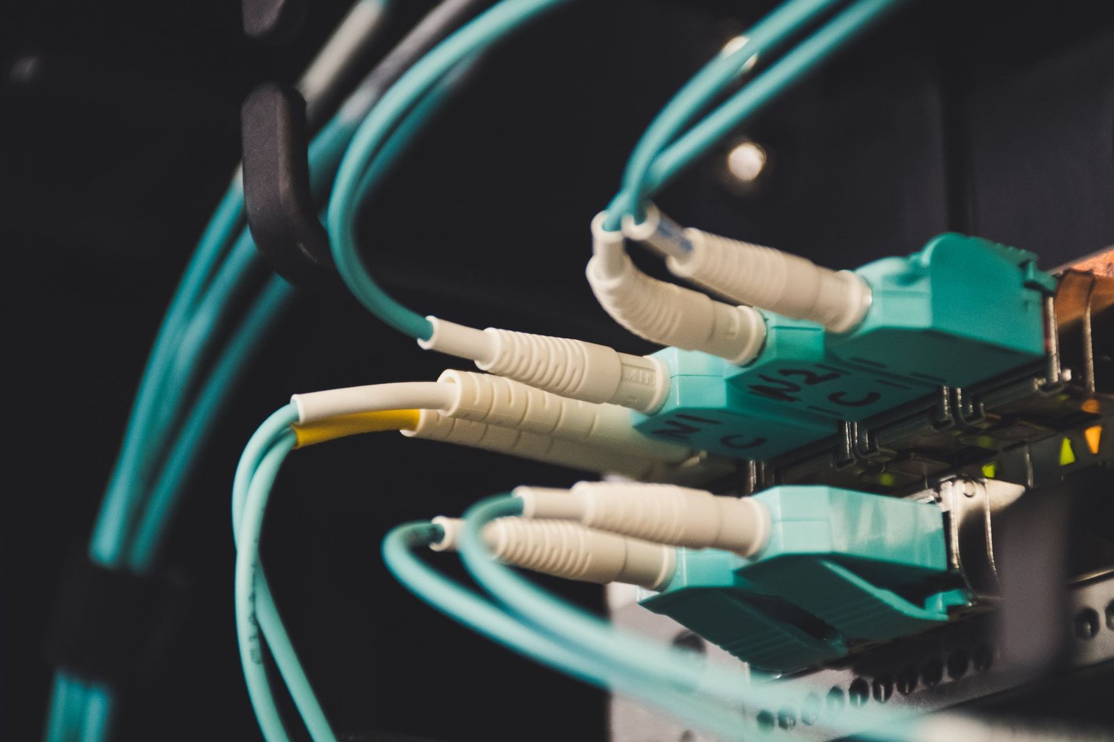 Close-up of fiber optic cables and ports inside a server room.