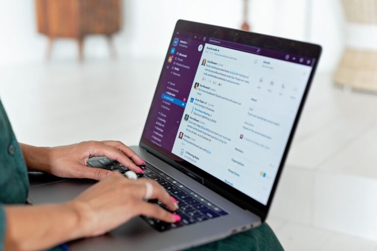 Close-up of hands typing on a laptop keyboard.