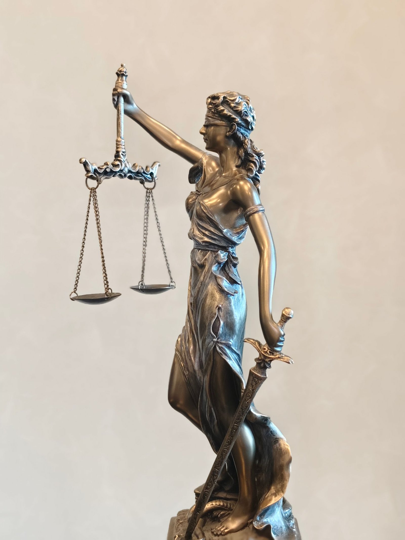 Bronze statue of Lady Justice holding scales and a sword.