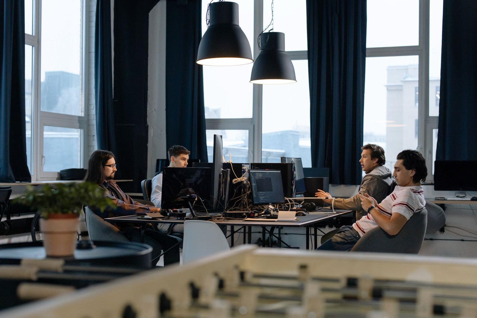 Workers collaborating at desks in a modern office with computers.