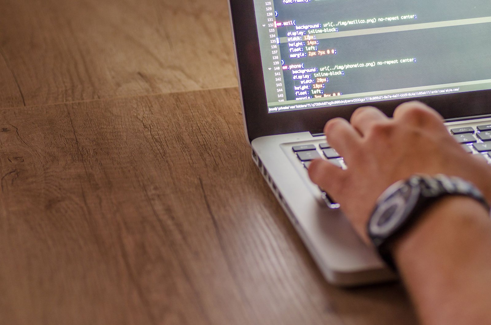 Close view of a laptop screen showing a code editor with syntax highlighting.