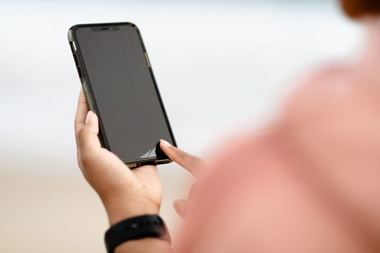 A person holding a modern smartphone, with the bright screen visible.