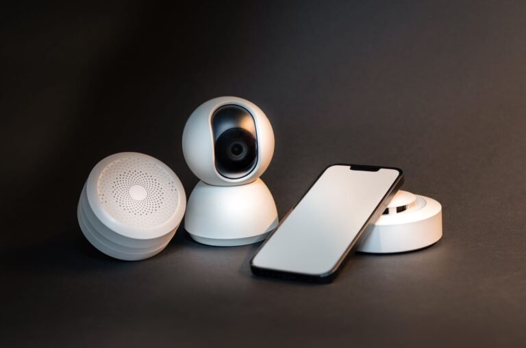A smart speaker on a living room table with a smartphone nearby.