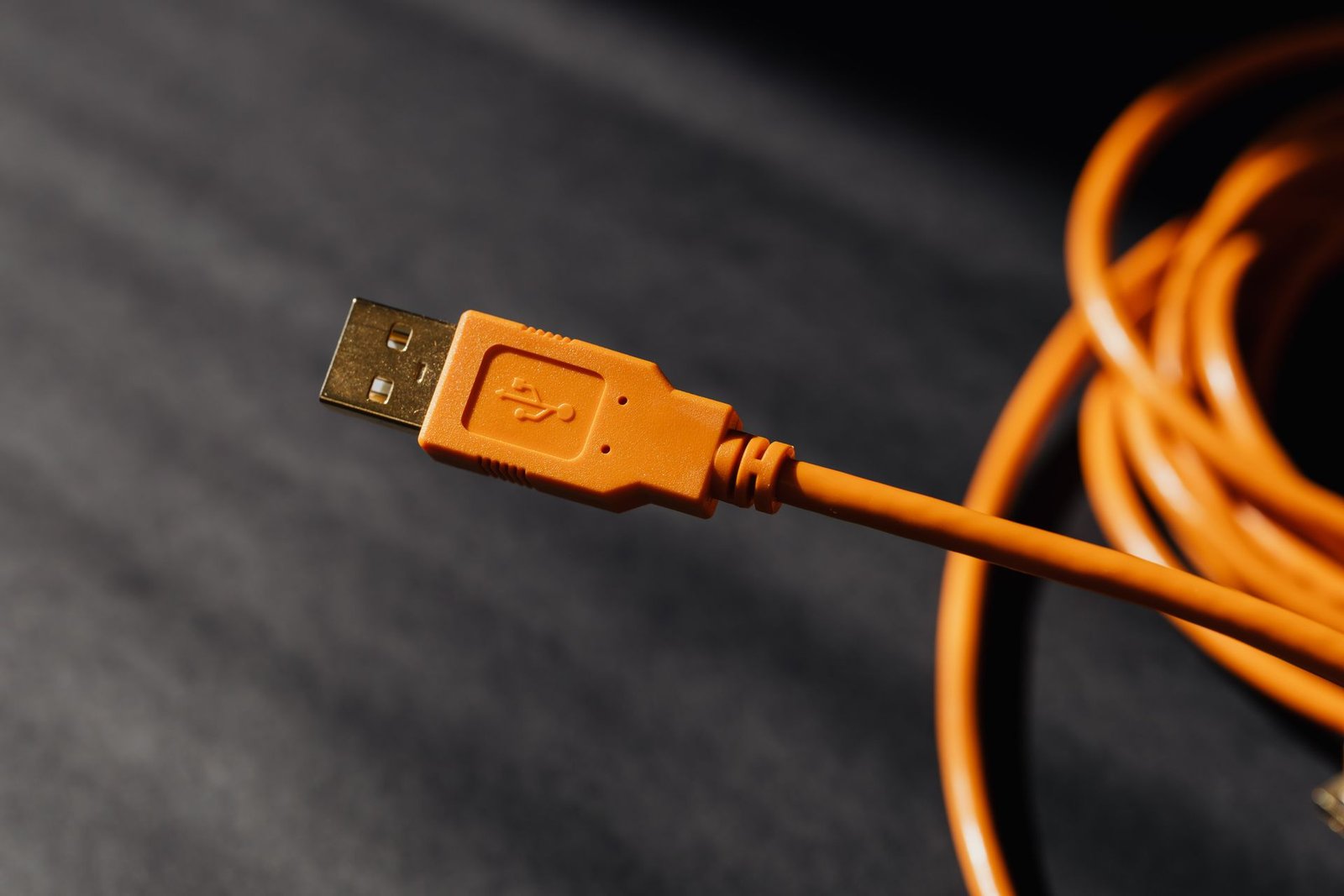 A laptop charging via USB-C on a desk with a compact power adapter.
