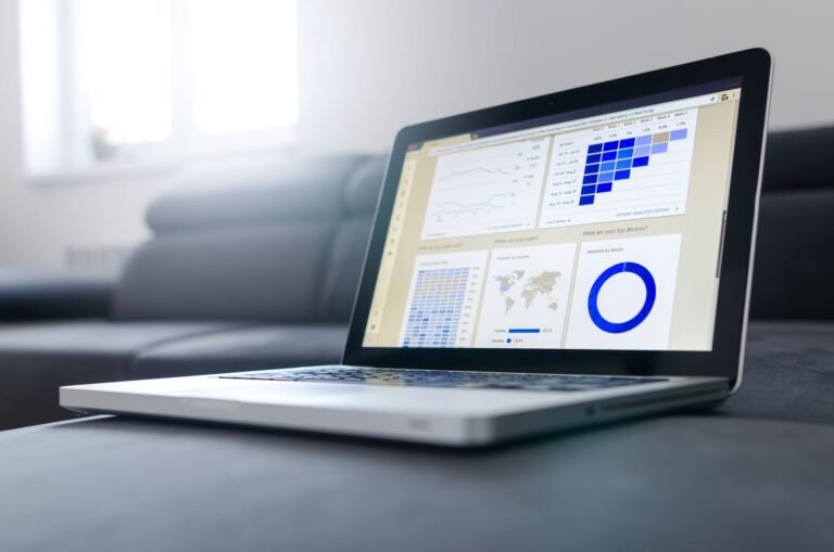 Laptop screen displaying colorful data analytics charts and graphs in a bright room.