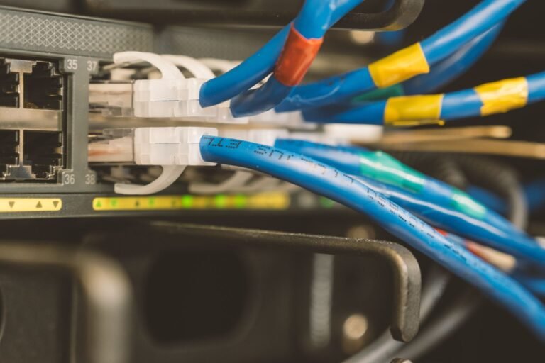 Network switch with a blue ethernet cable connected, showing physical network connections.