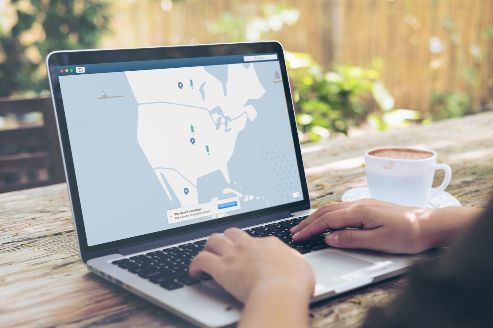 Laptop with a VPN interface on screen next to a cup of coffee.