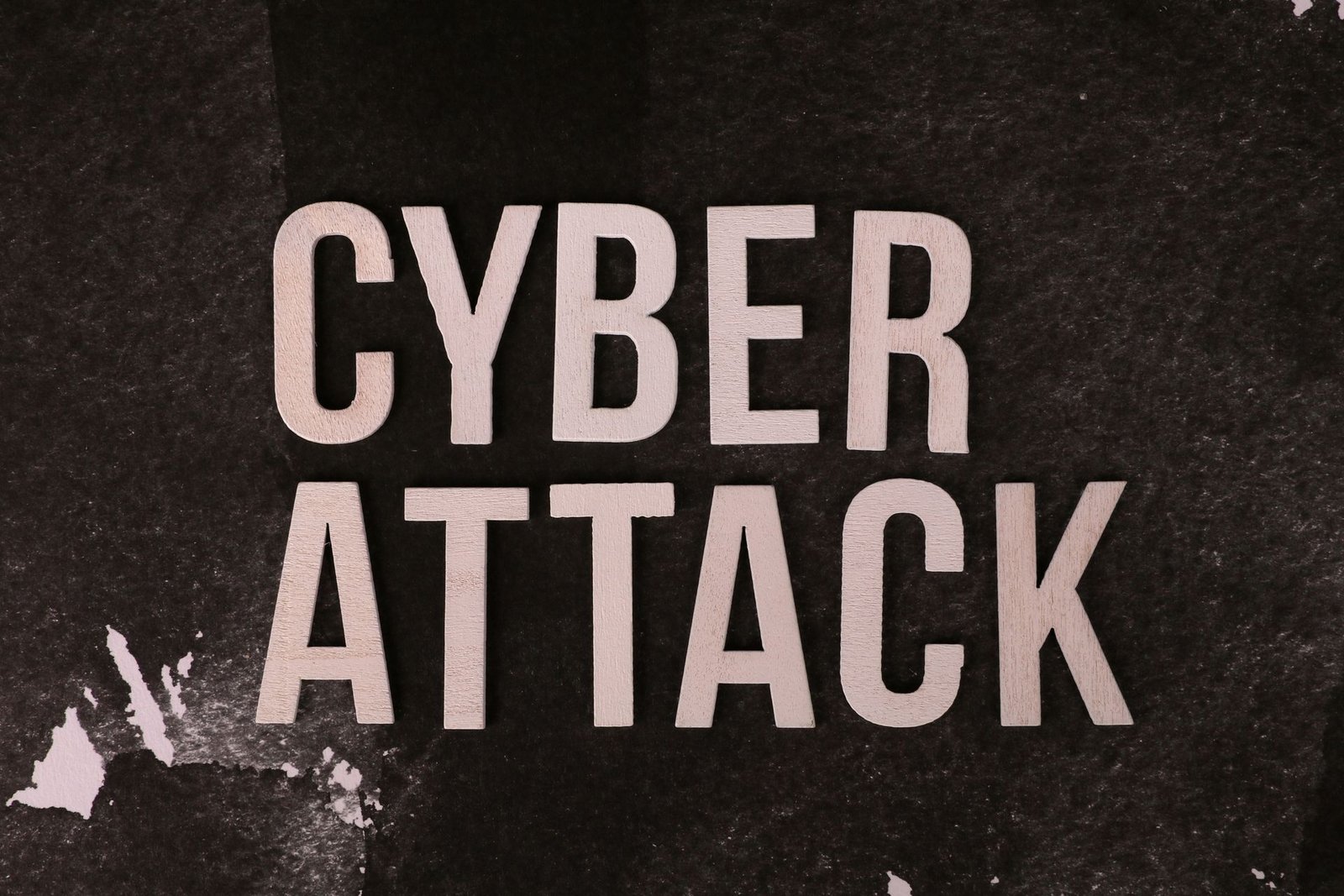 The words Cyber Attack stamped on a dark textured background.