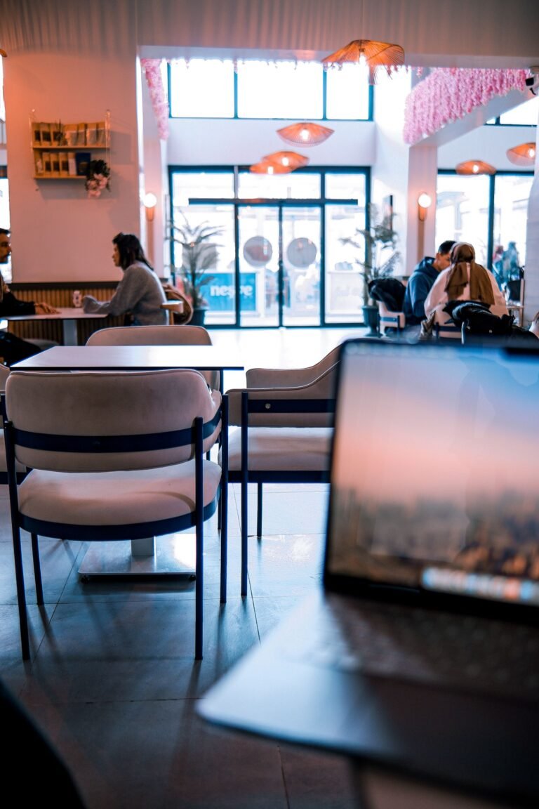 Modern cafe interior with people working on laptops.