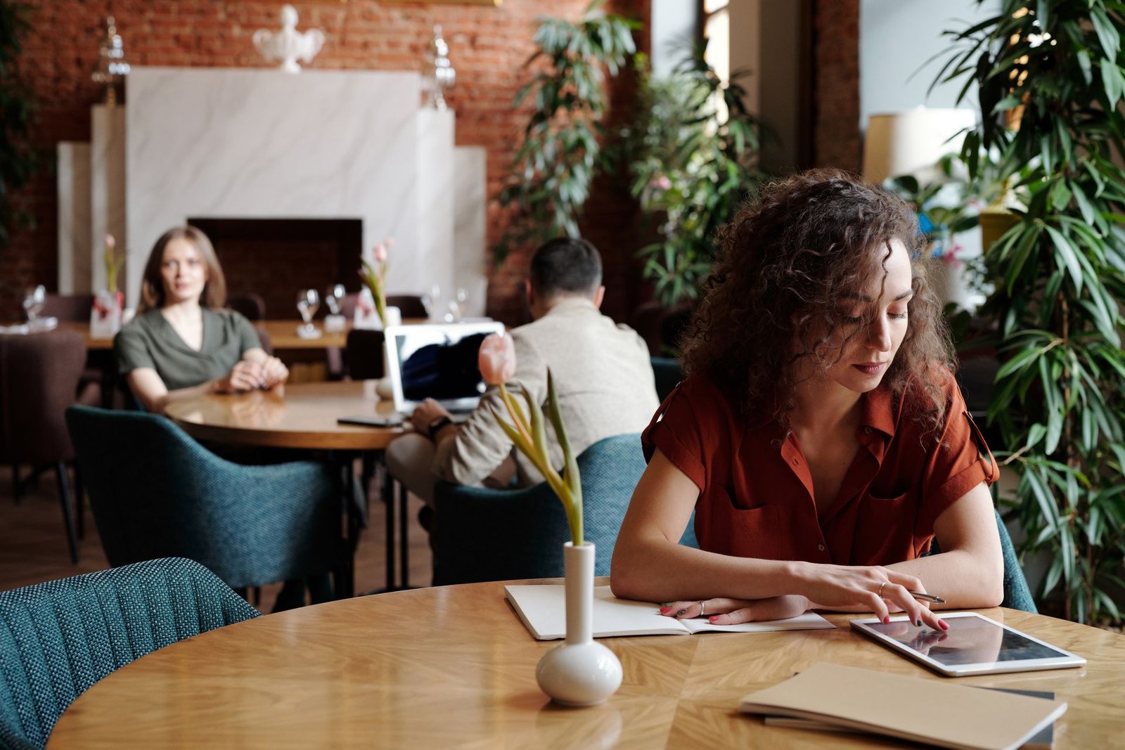 Woman working on a tablet in a restaurant.