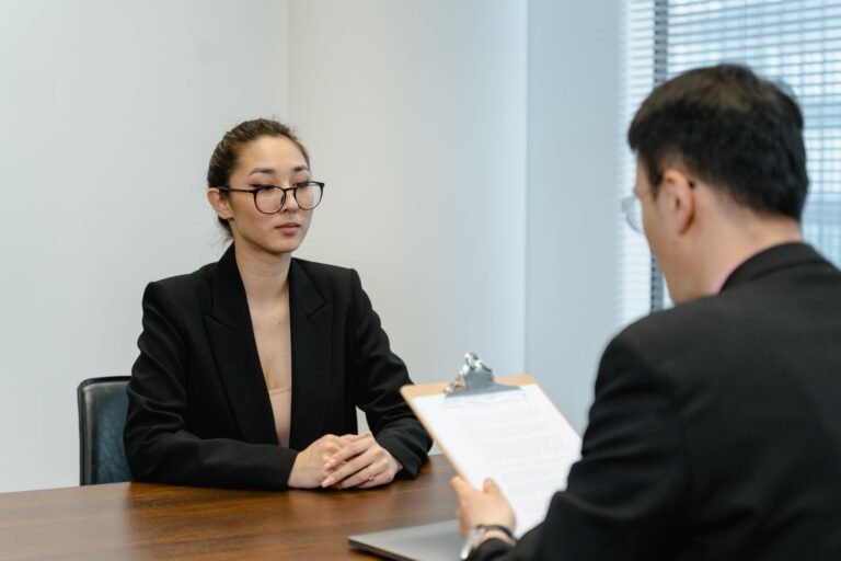 Two professionals in a job interview in a modern office setting.