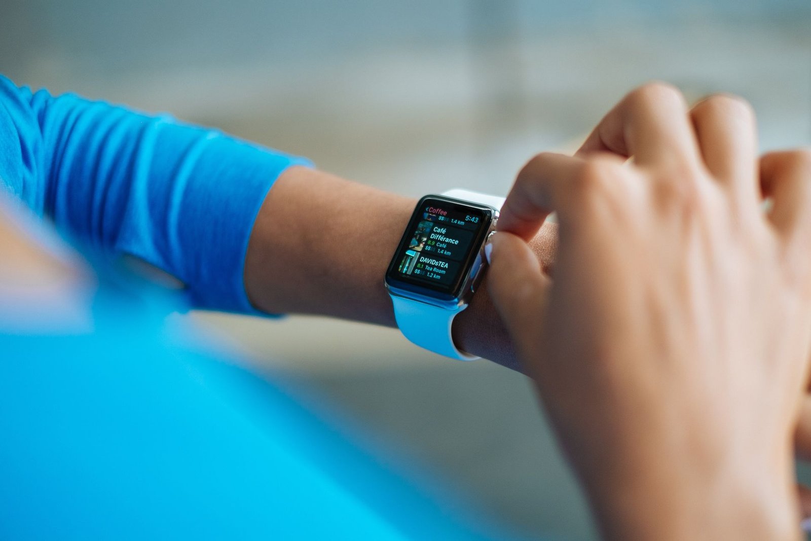 A person interacting with a smartwatch showing a fitness app on the screen.