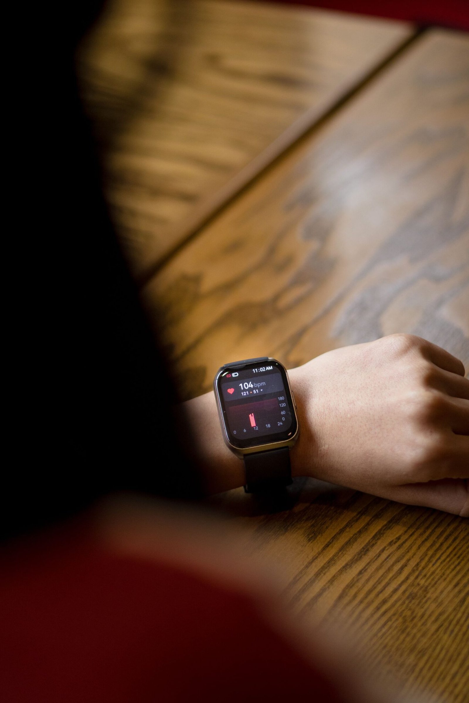 Close-up of a smartwatch on a wrist showing a heart rate of 104 beats per minute.