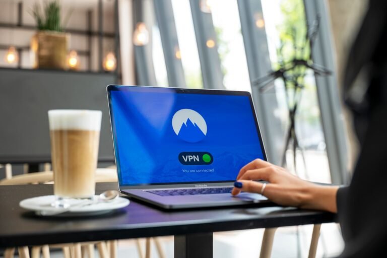 A person using a laptop with a VPN connection in a modern cafe setting.