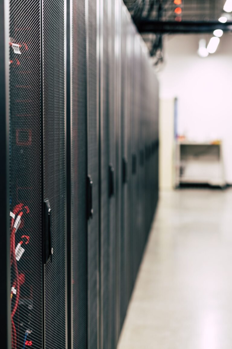 A corridor of server racks in a modern data center glowing blue.