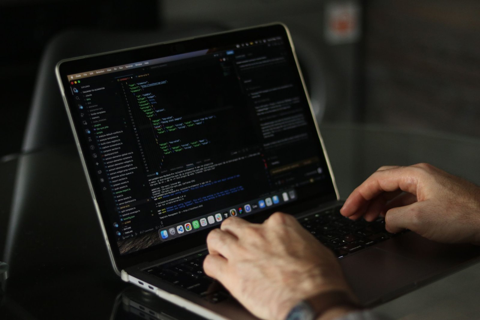 Close-up of a developer's hands typing code on a laptop.