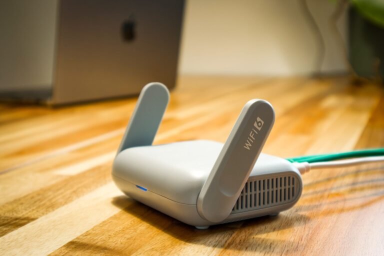 A modern WiFi router with antennas and a cable on a wooden desk.